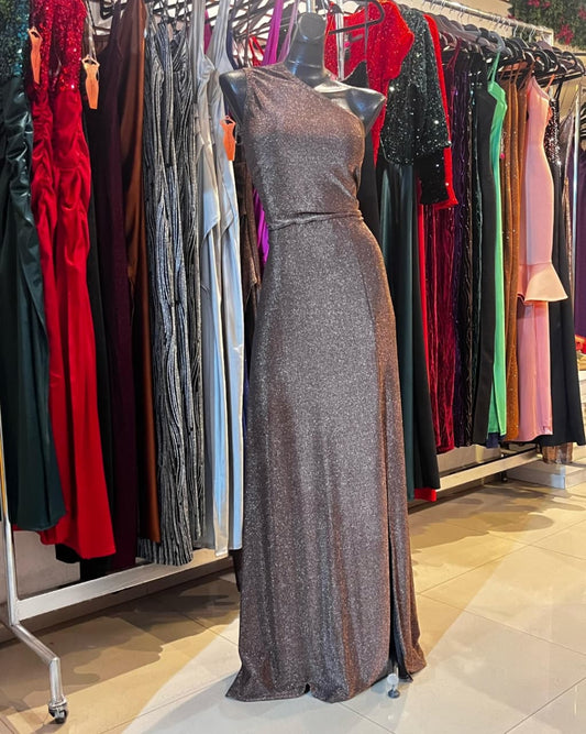 VESTIDO LARGO CON GLITTER COLOR COBRE, DE UN SOLO HOMBRO CON FALDILLA LÍNEA A Y APERTURA EN LA PIERNA